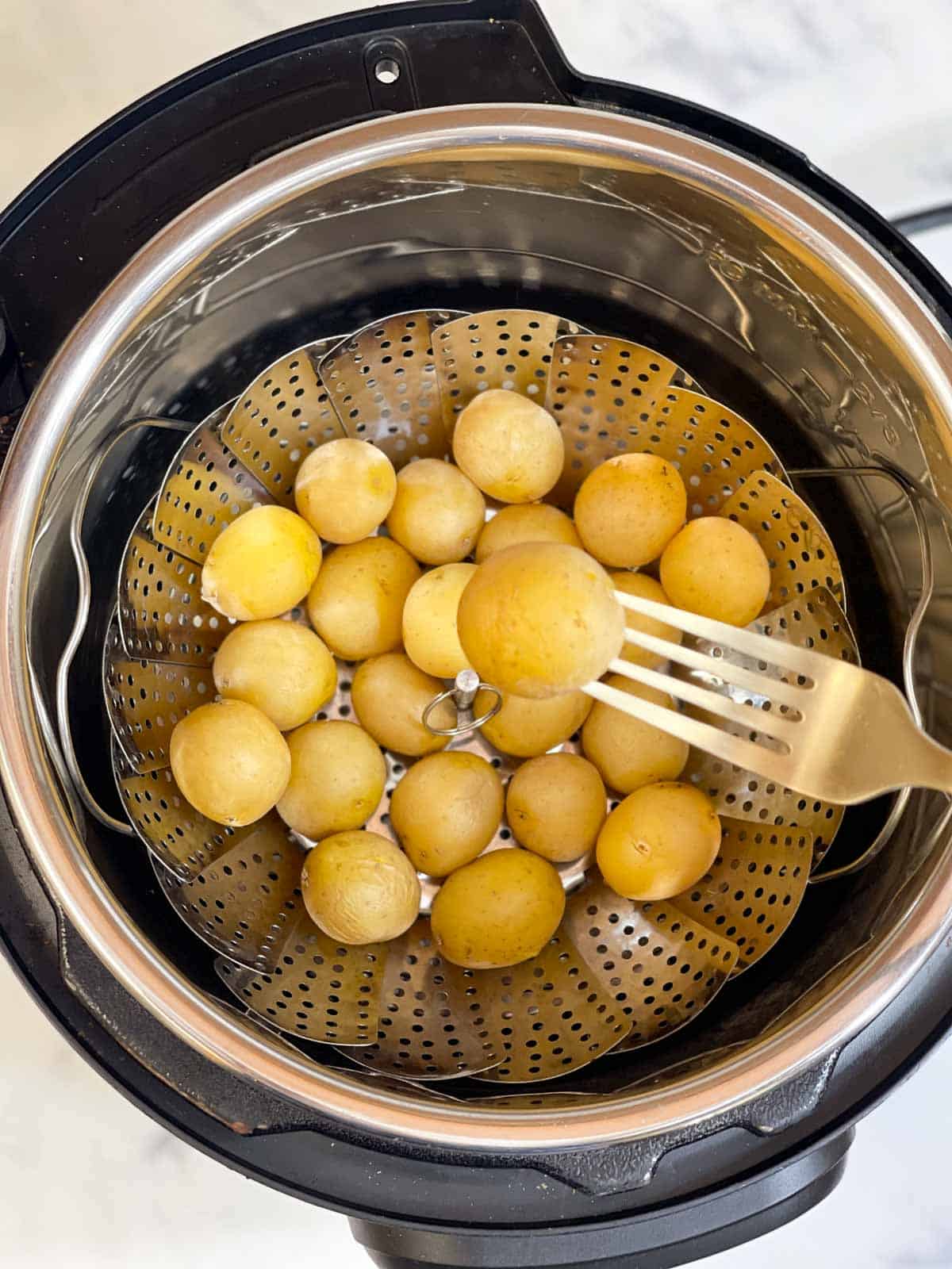steamed baby potatoes in a steamer basket in instant pot