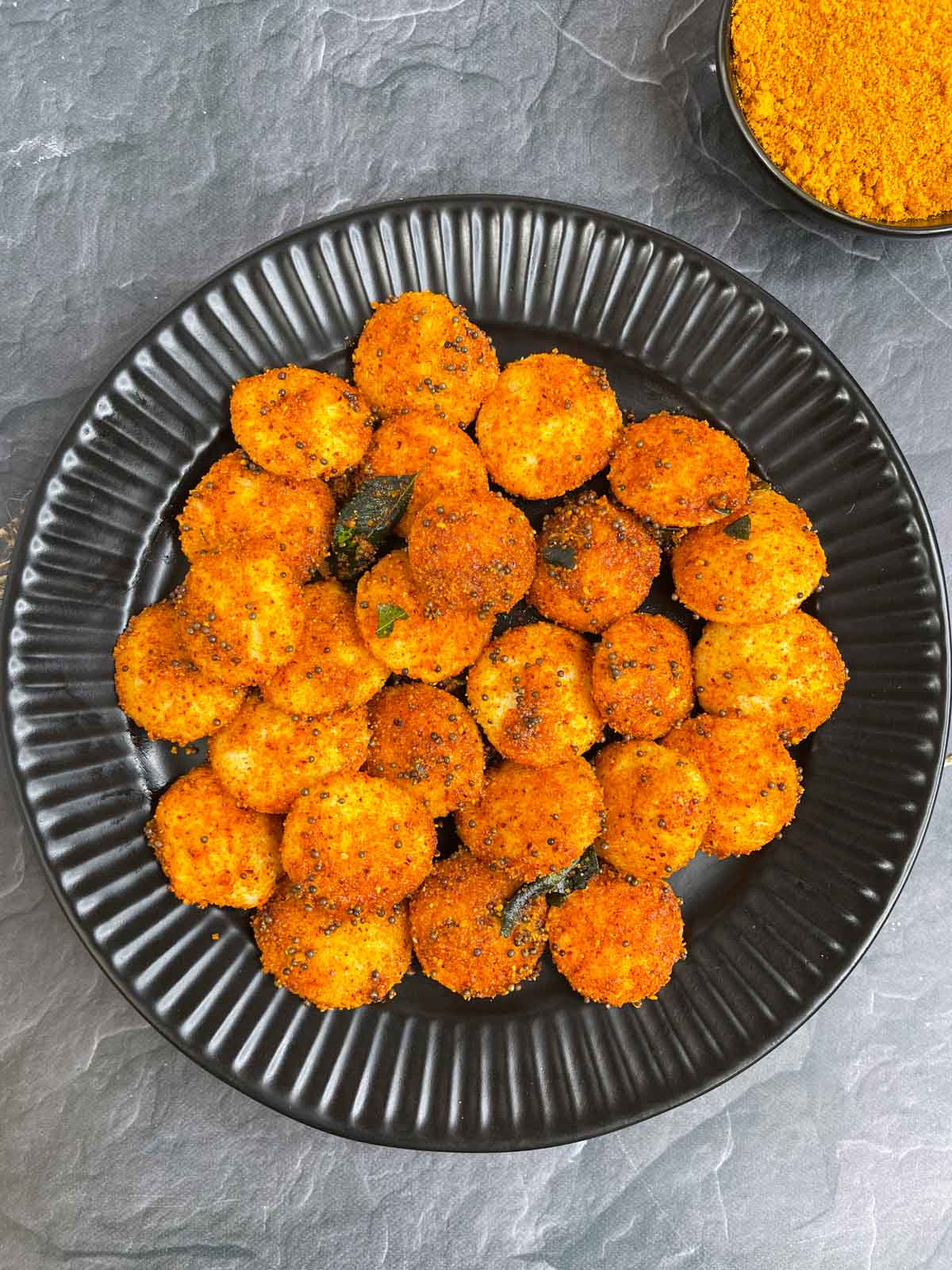 podi idli served on a plate with idli podi on the side