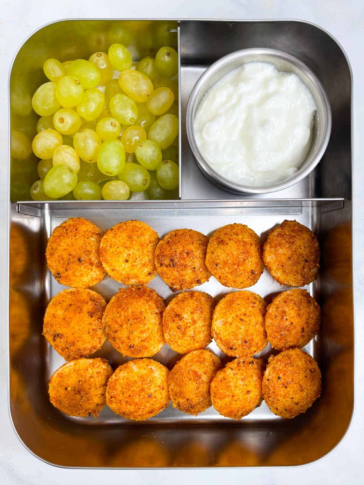 podi idli, yogurt and green grapes in bento steel lunch box