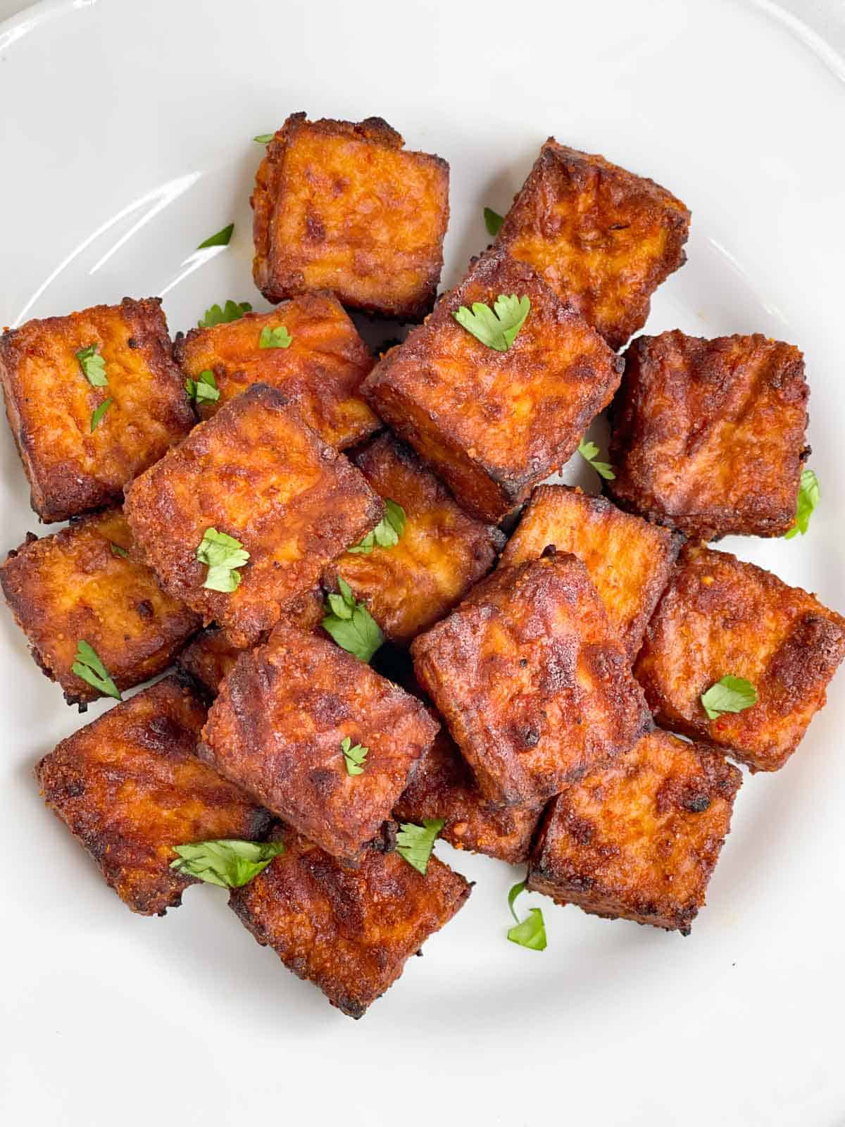 crispy air fryer tofu served on a plate garnished with cilantro