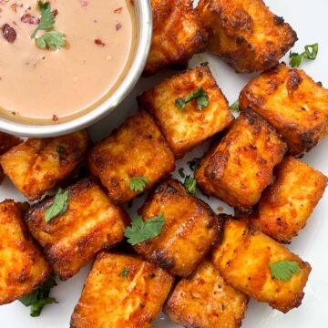 air fryer tofu served on a plate with peanut butter dressing on the side