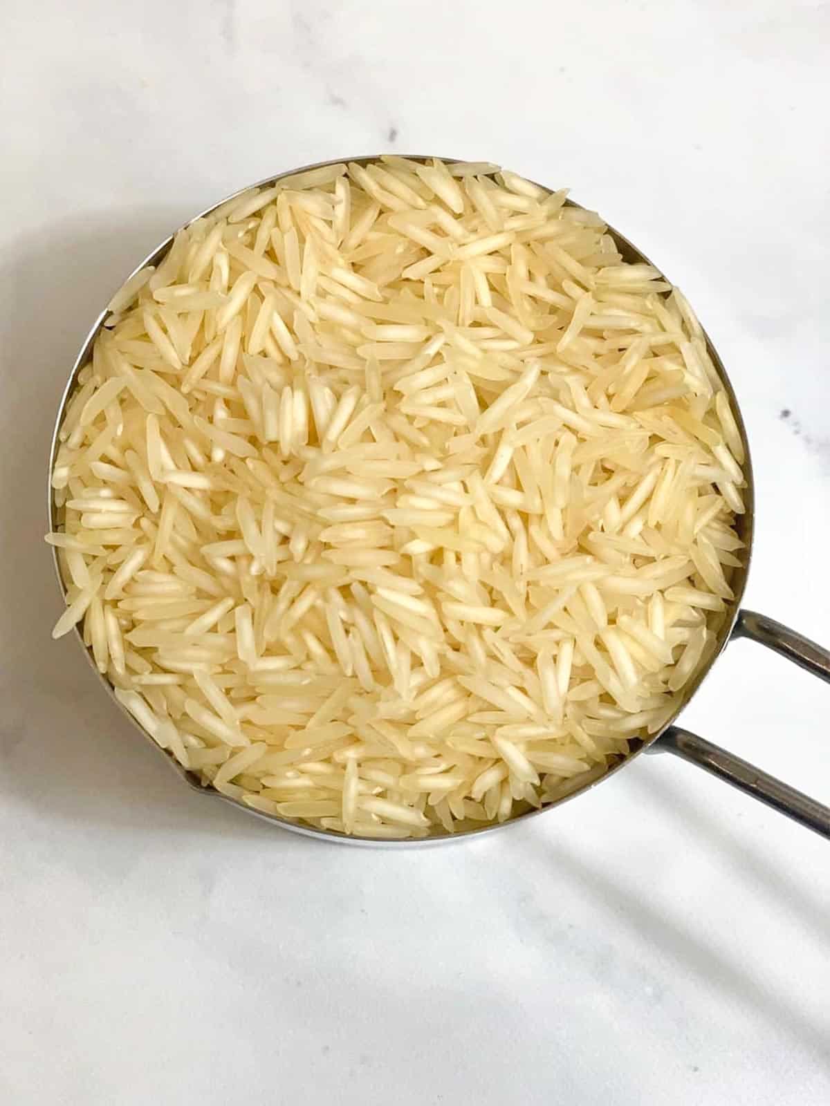 uncooked basmati rice in a measuring cup