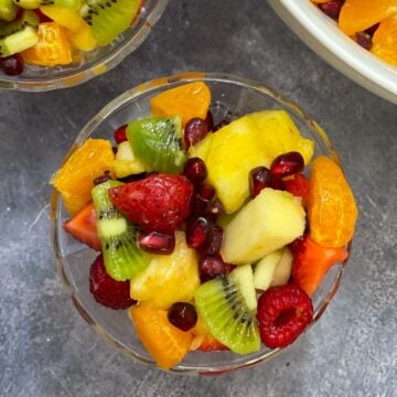fruit salad with honey lime dressing served in a glass bowl