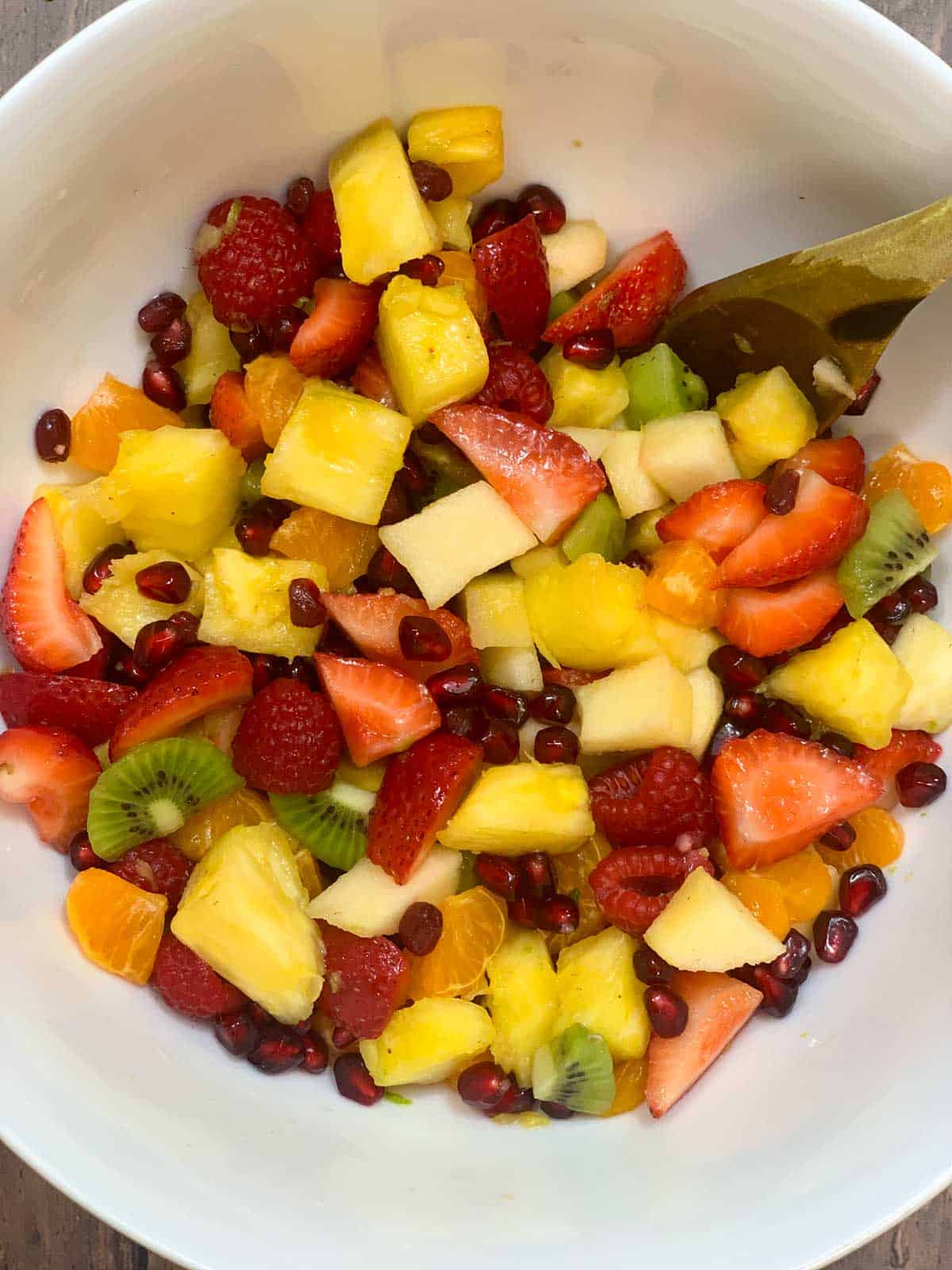 honey lime fruit salad recipe in a bowl with a spoon
