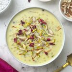 sabudana kheer (indian tapioca pudding) served in a bowl garnished with rose petals and nuts and spoon on the side