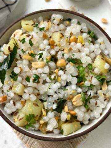sabudana khichdi served in a bowl with roasted peanuts on the side