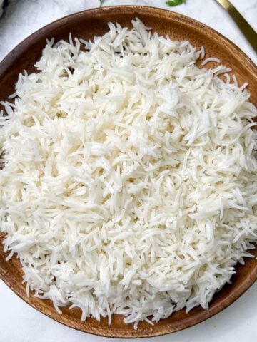 cooked white basmati rice on a plate with spoon on the side