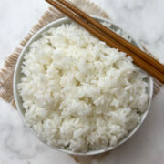 instant pot calrose rice served in a white bow with chopsticks on the top