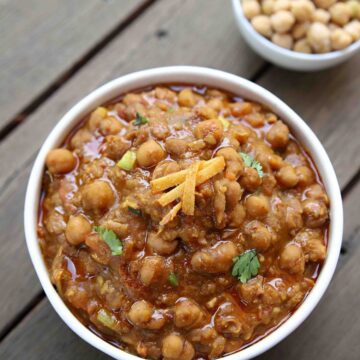 Pindi chole served in a bowl with cooked chickpeas on the side.