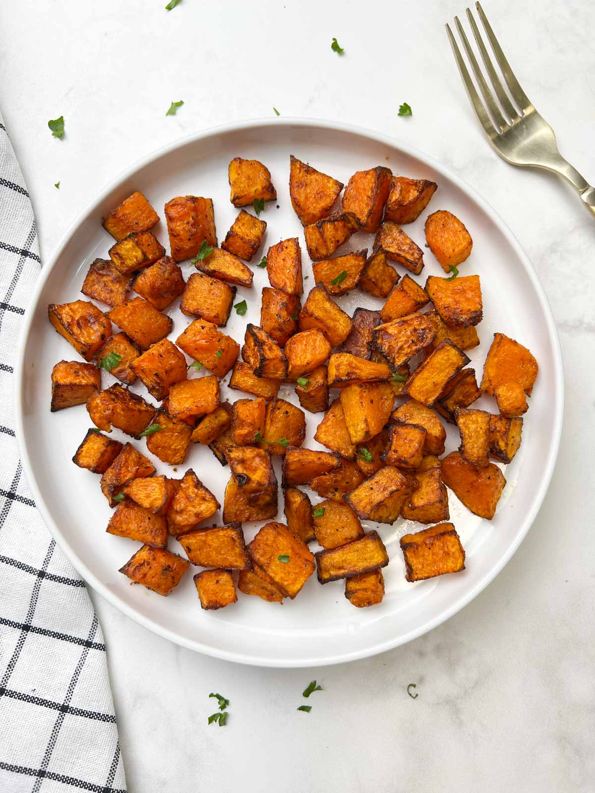 roasted butternut squash served in a plate with fork in the side