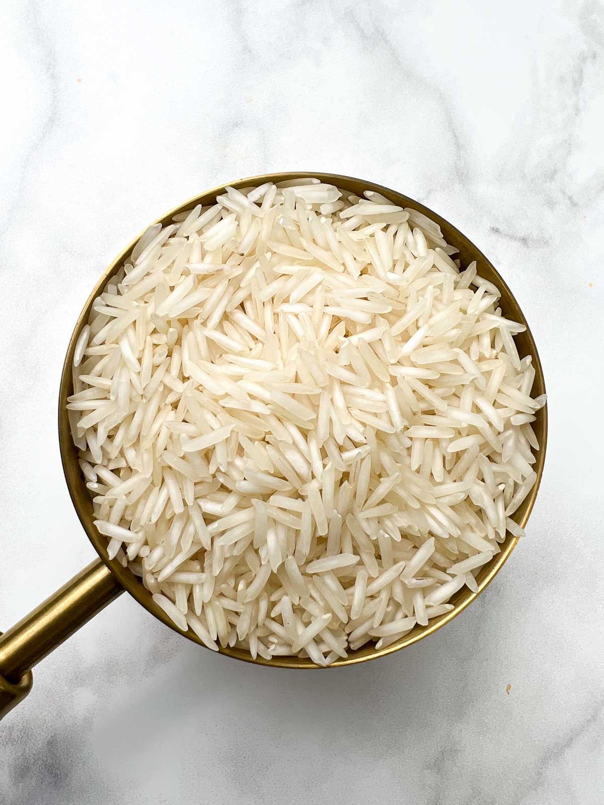 white raw basmati rice in a measuring cup