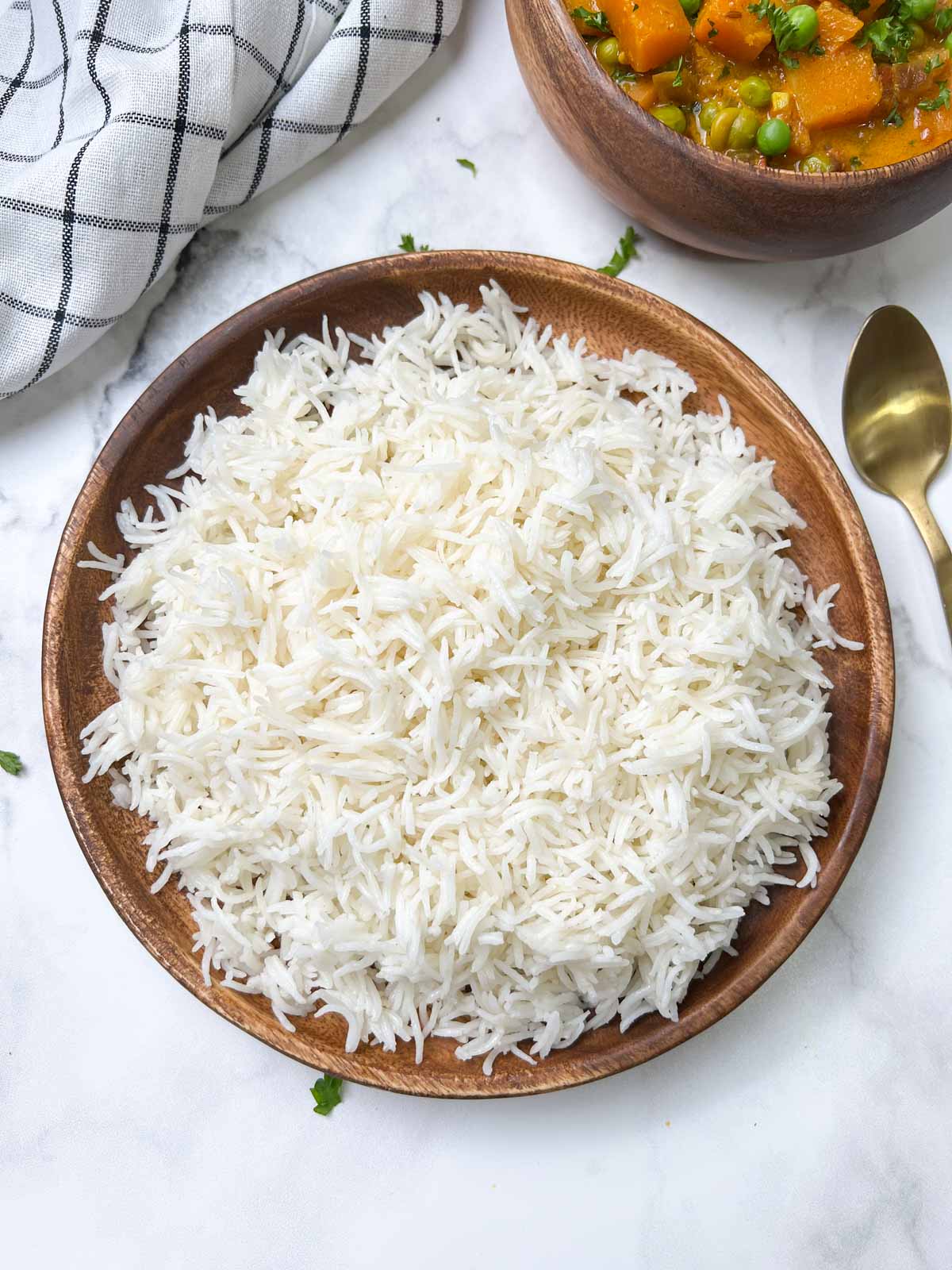 cooked white long grain on a plate with spoon on the side