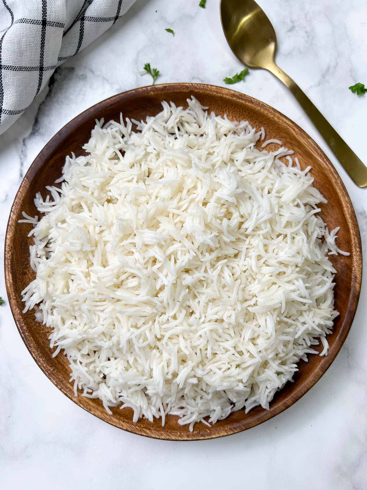 cooked white basmati rice on a plate with spoon on the side 