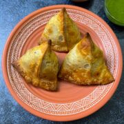 air fryer samosas on a plate with chutneys on the side