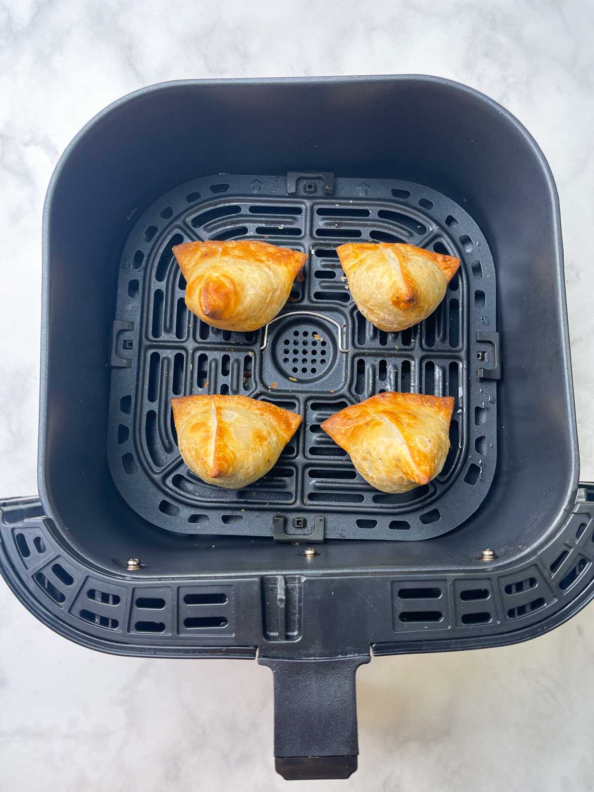 air-fried frozen samosa in the air fryer basket