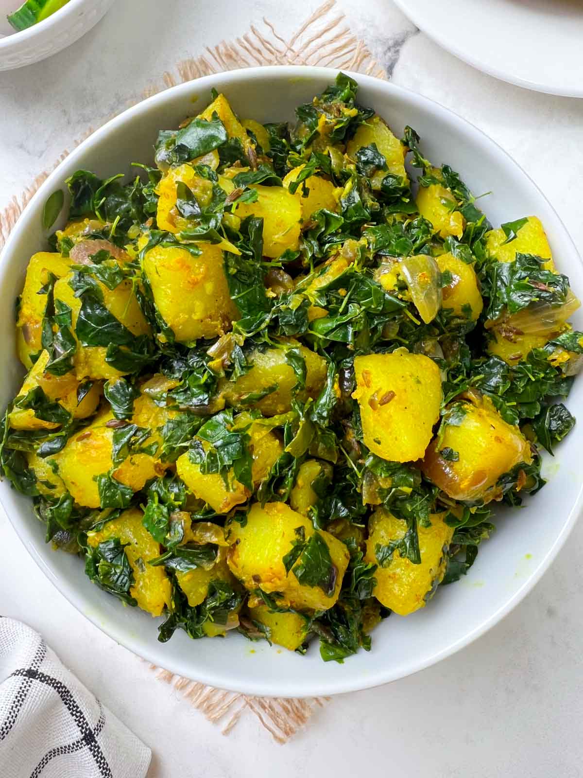 aloo moringa sabzi (potato moringa leaves) served in a bowl