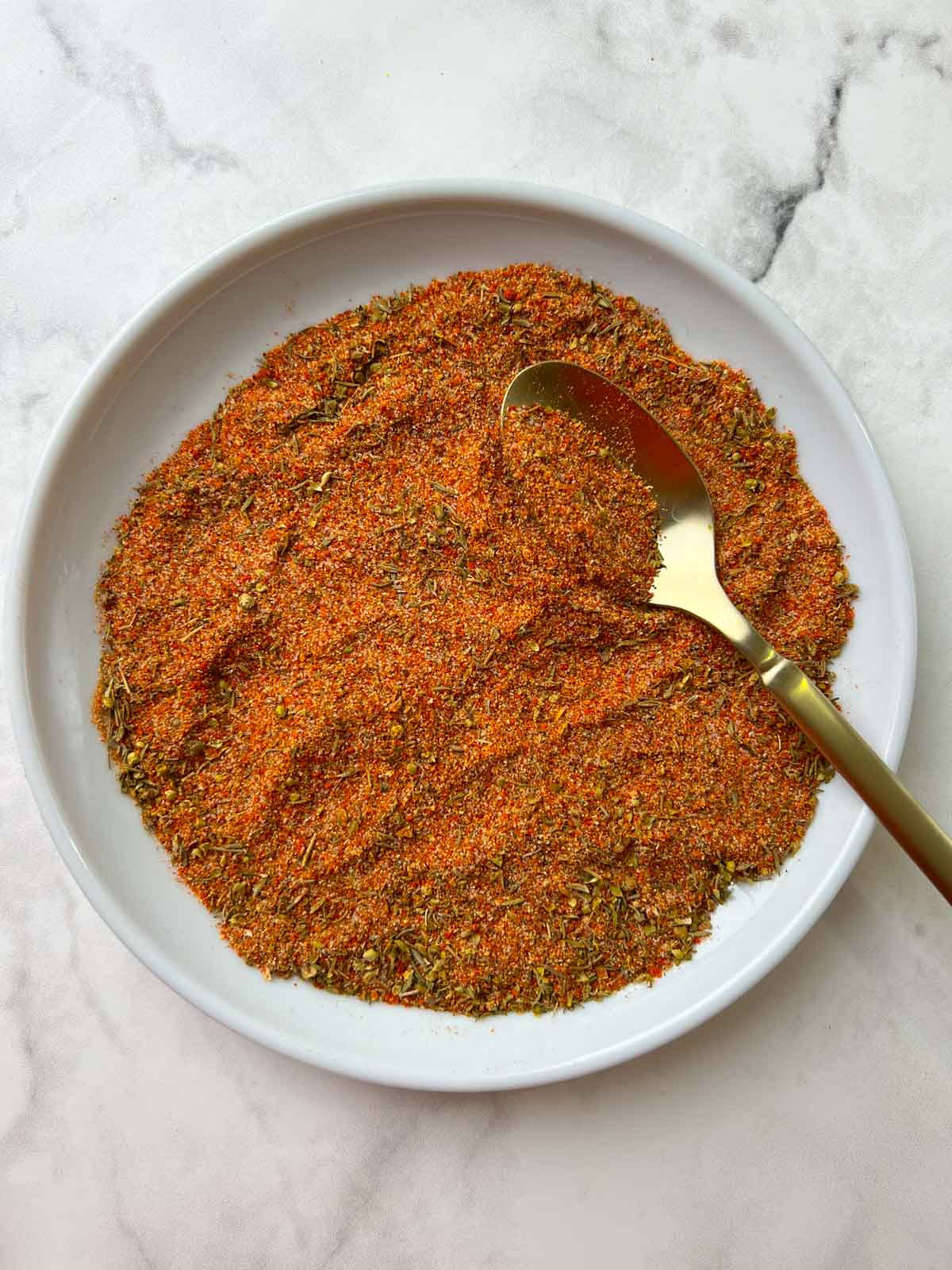 homemade cajun seasoning (Cajun Spice Mix) on a plate with a spoon