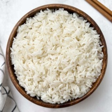 instant pot coconut rice served in a wooden bowl with chopsticks on the side