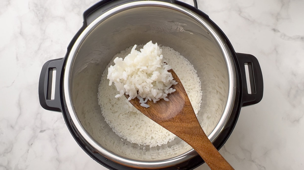 cooked calrose rice in a wooden spoon