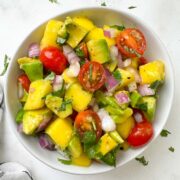 avocado mango salad served in a white bowl garnished with cilantro