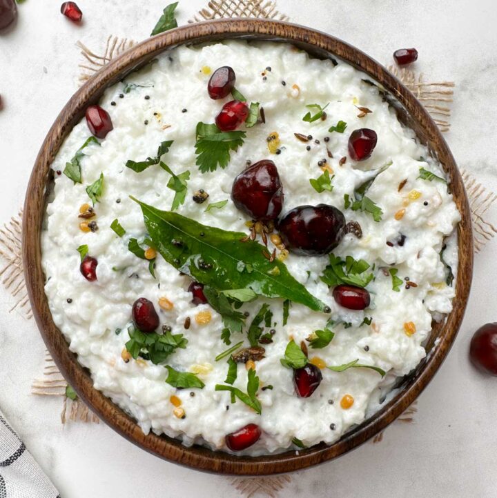 curd rice (thayir saddam) served in a wooden bowl with the tempering on the top
