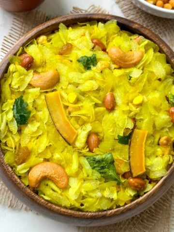 roasted poha chivda (indian namkeen) served in a wooden bowl with sev on the side