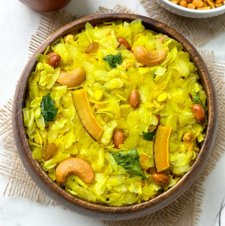 roasted poha chivda (indian namkeen) served in a wooden bowl with sev on the side
