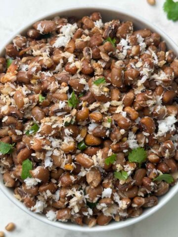 red chori sundal (beans sundal) served in a white bowl garnished with cilantro