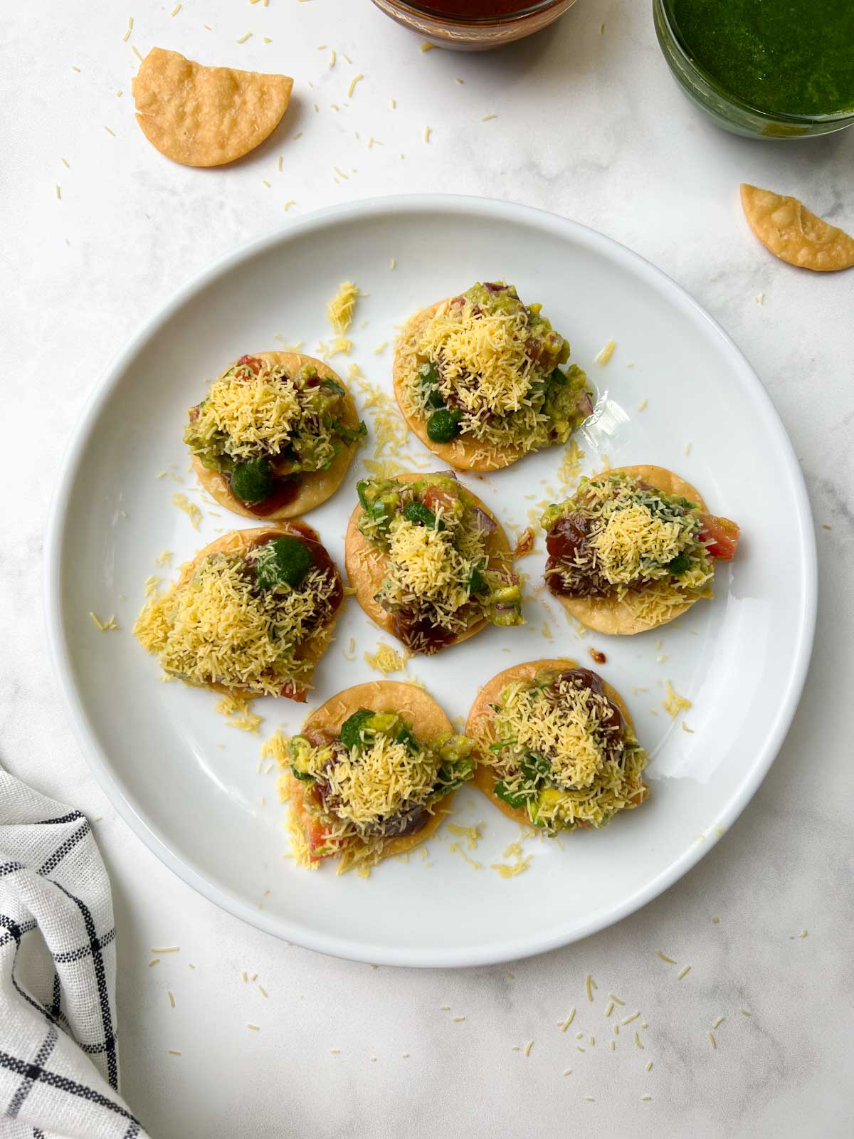 avocado papdi chaat served on a serving plate with chutneys on the side