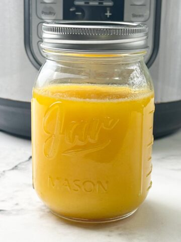 solidified ghee in a mason jar with instant pot behind