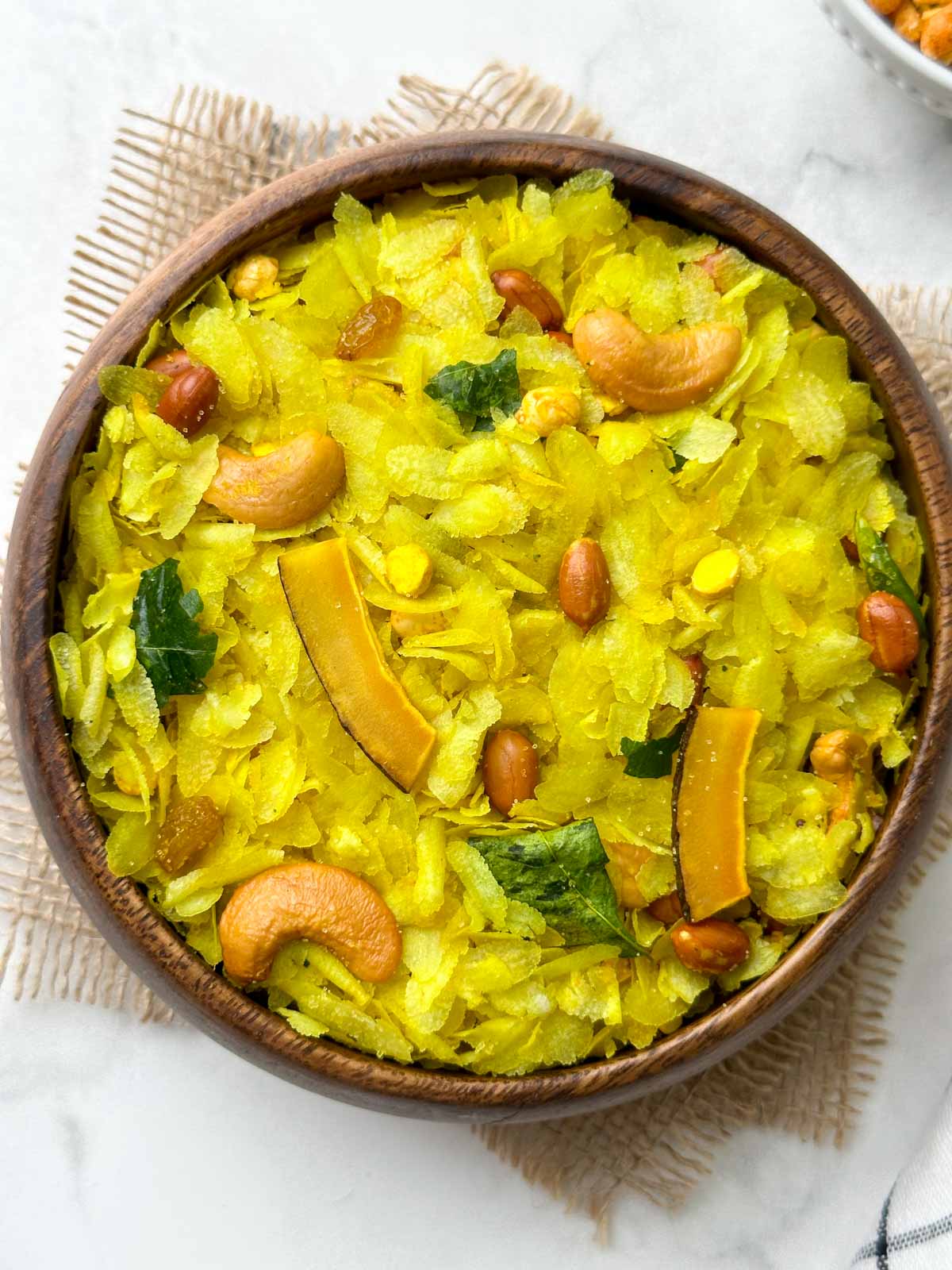 roasted poha chivda (indian namkeen) served in a wooden bowl with sev on the side