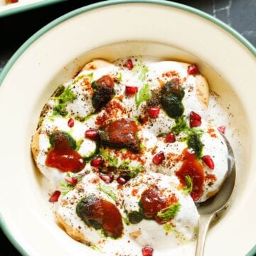 dahi vada served in a bowl with a spoon