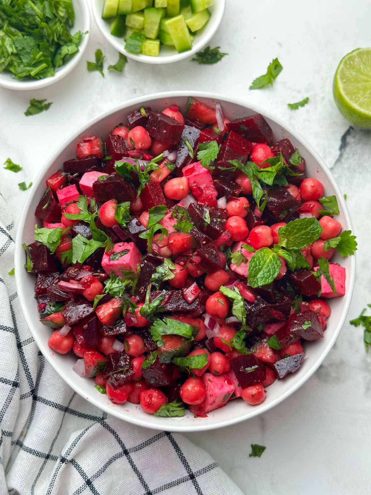 beetroot chickpea salad served in a bowl with cilantro on the side