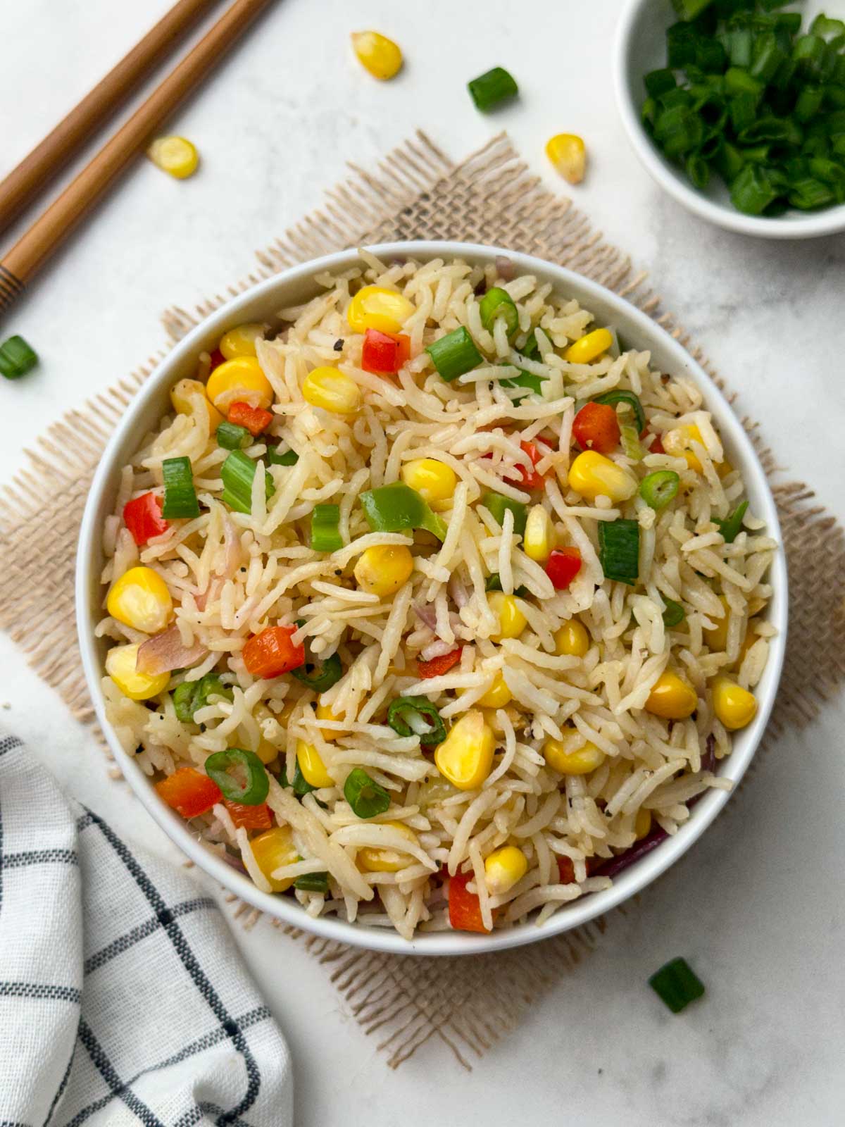 sweet corn fried rice recipe served in a bowl with chop sticks and green onions on the side