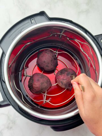 perfectly boiled beets and fork inserted to check the doneness