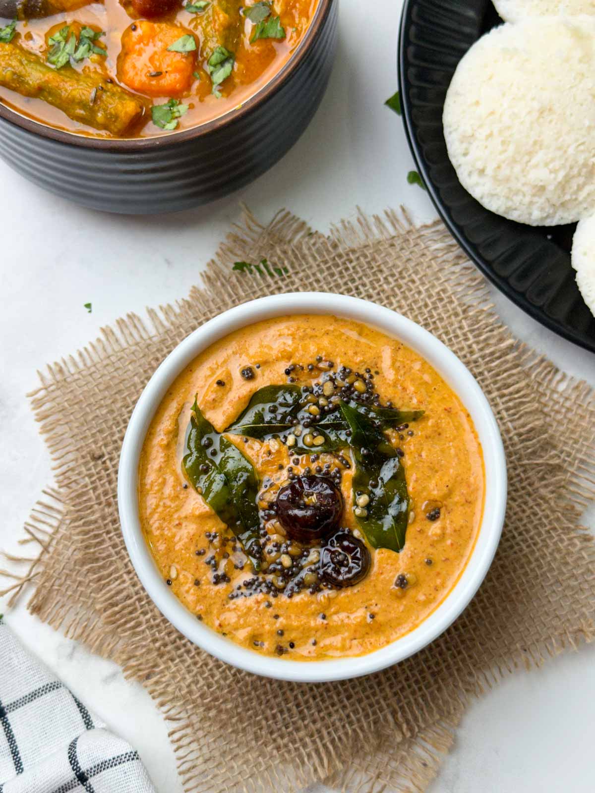 Peanut Chutney served in a white bowl with idli and vegetable sambar on the side