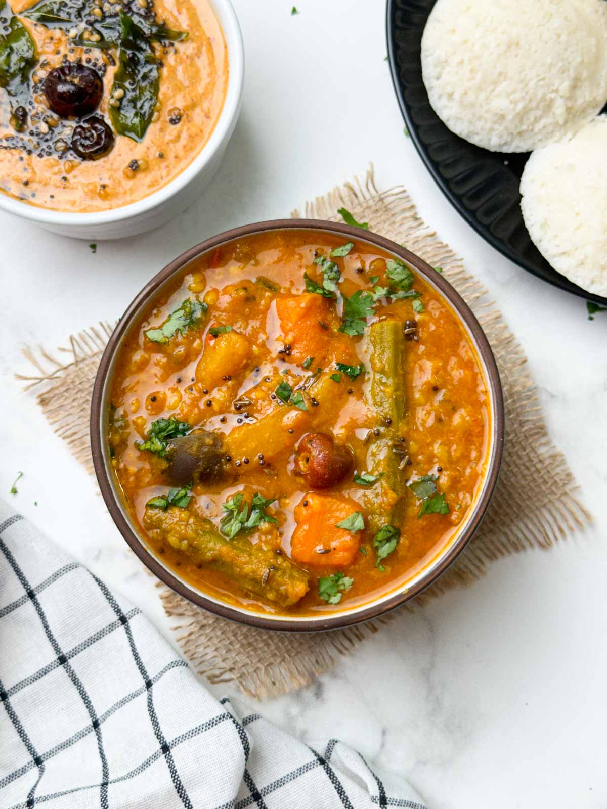 instant pot vegetable sambar served in a bowl with peanut chutney and idli on the side