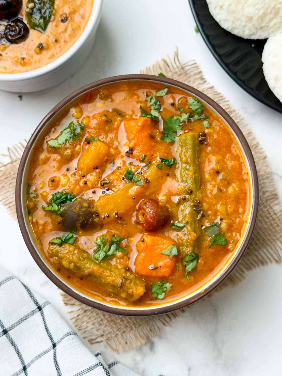 instant pot vegetable sambar served in a bowl with peanut chutney and idli on the side
