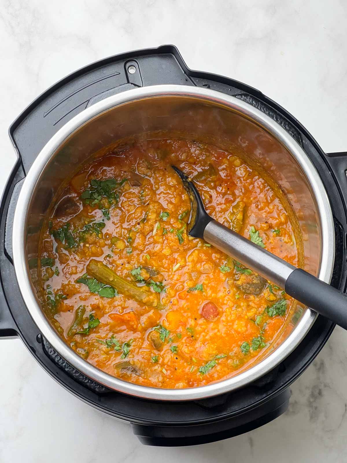 south indian vegetable sambhar in the pot with a spoon