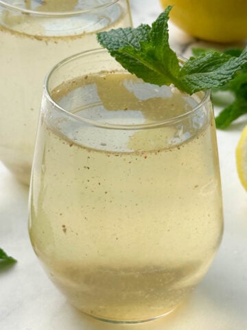 nimbu pani (shikanji) served in a glass garnished with mint leaves and lemon on the side
