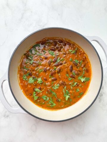 rajma masala curry in the dutch oven garnished with coriander leaves