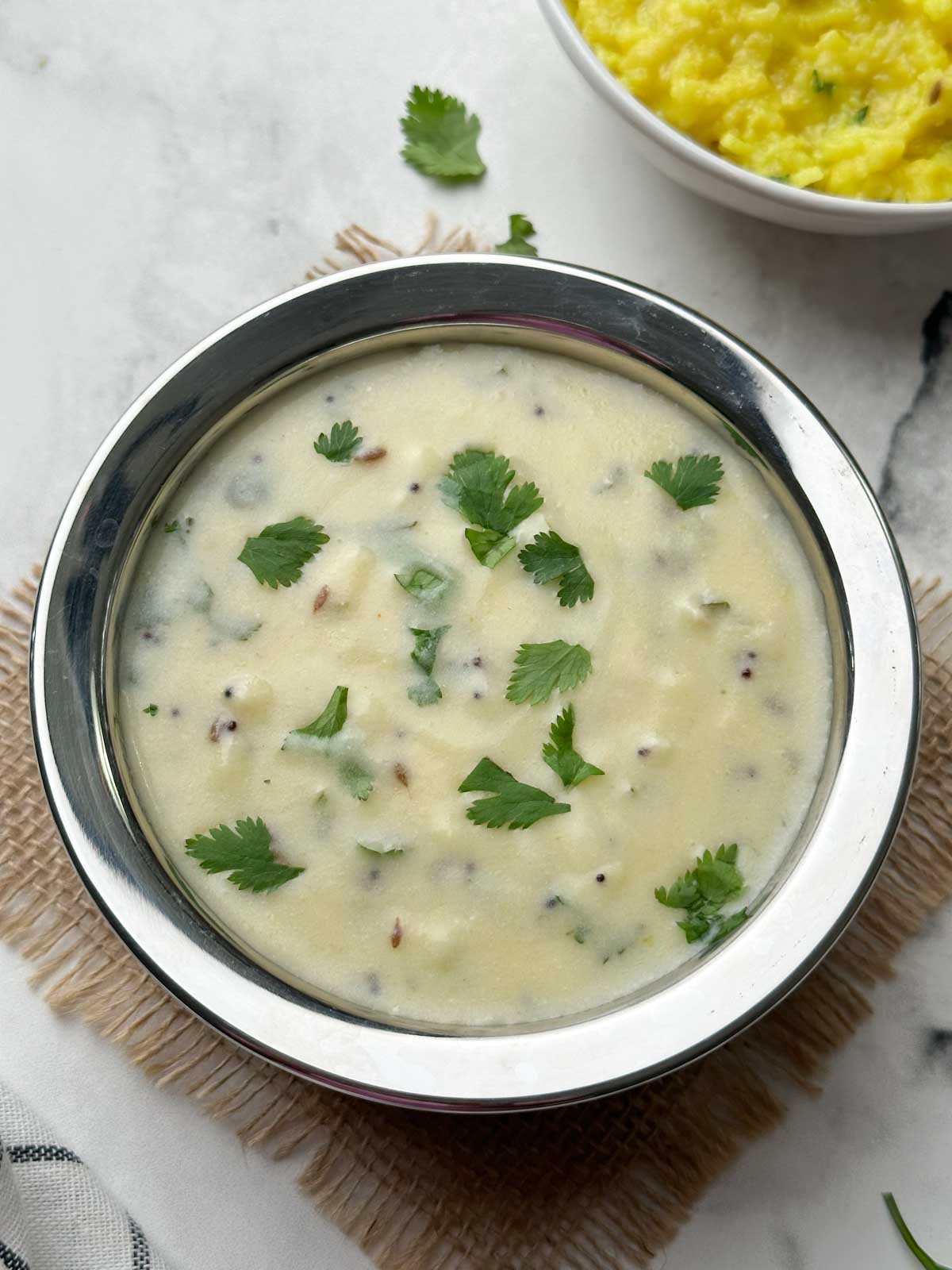 gujarati kadhi served in a bowl and khichdi on the side