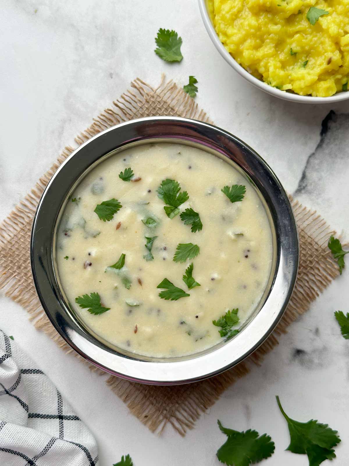 gujarati kadhi served in a bowl and khichdi on the side