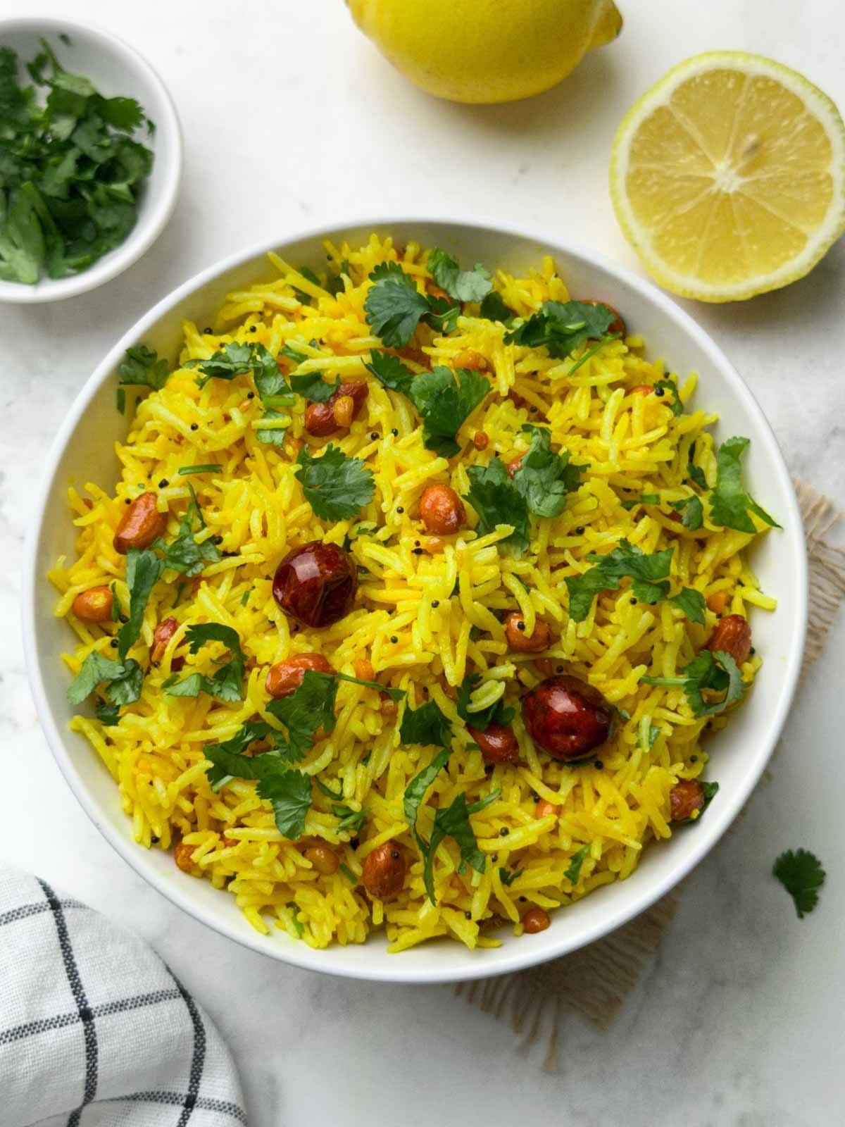 chitranna rice served in a bowl with lemon on the side