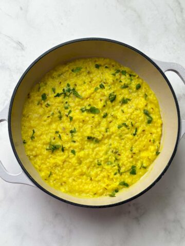 moong dal khichdi in a kadai garnished with coriander leaves
