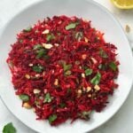 carrot beetroot salad served on a plate with a lemon on the side