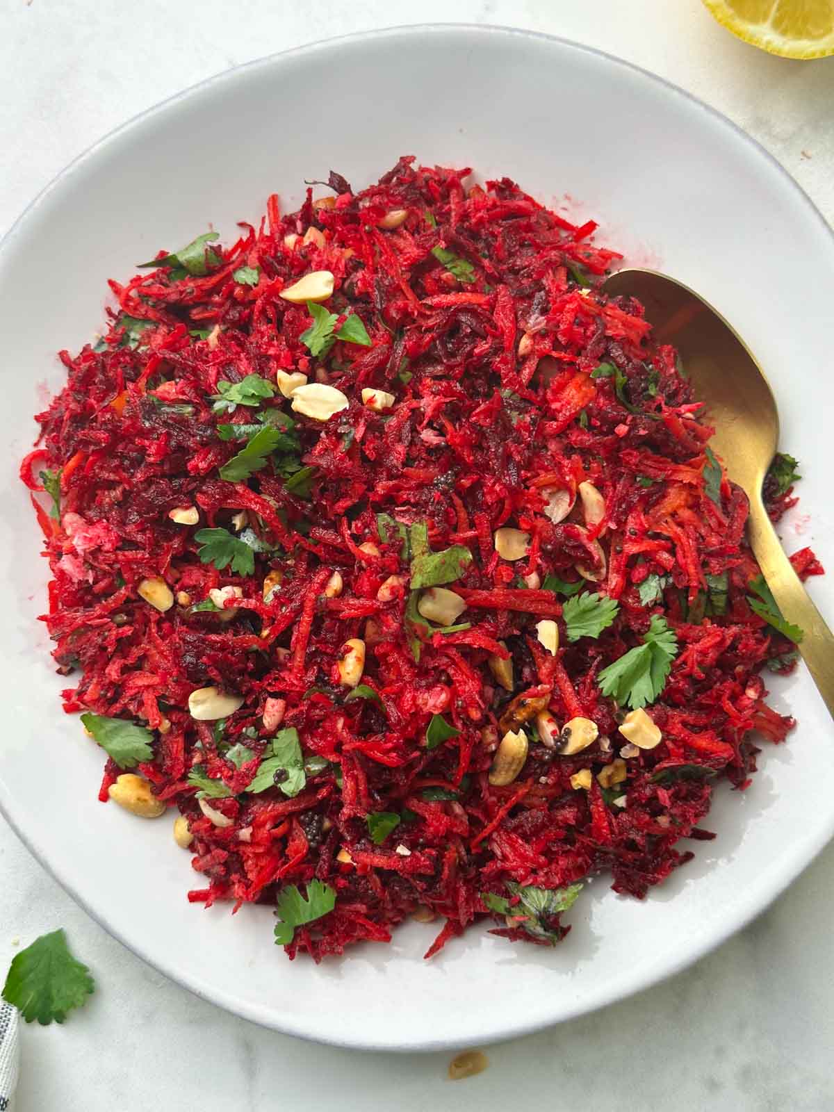 carrot beetroot salad served on a plate with a lemon on the side