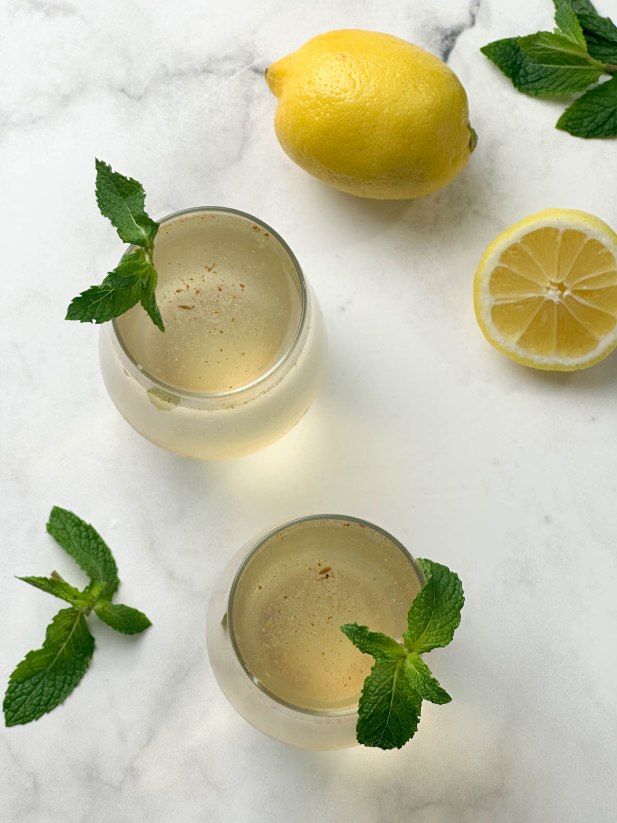 nimbu pani (shikanji) served in a glass garnished with mint leaves and lemon on the side