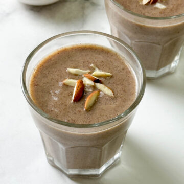ragi malt served in two glass cups garnished with slivered almonds