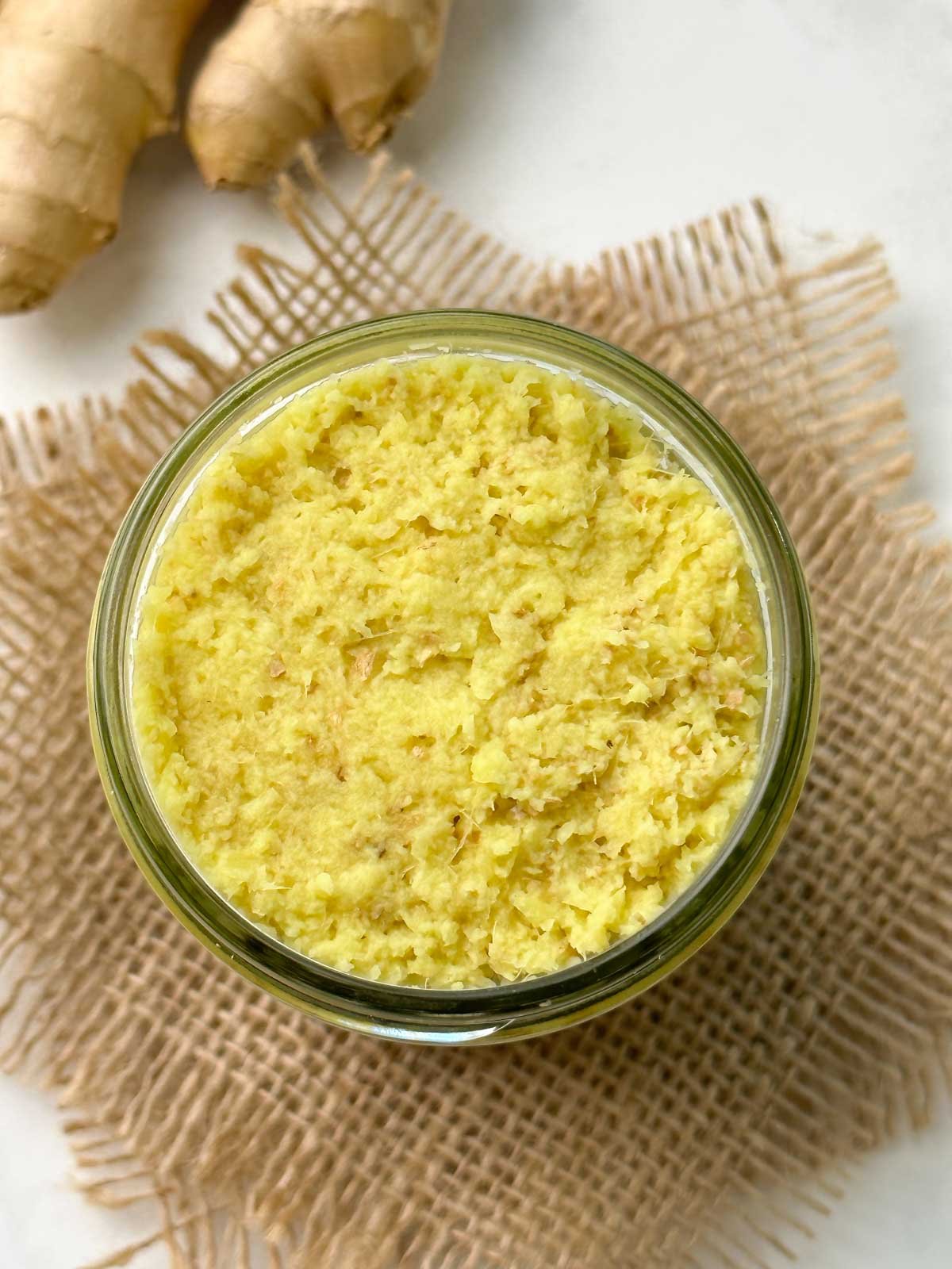 ginger paste in a glass jar with ginger knob on the side